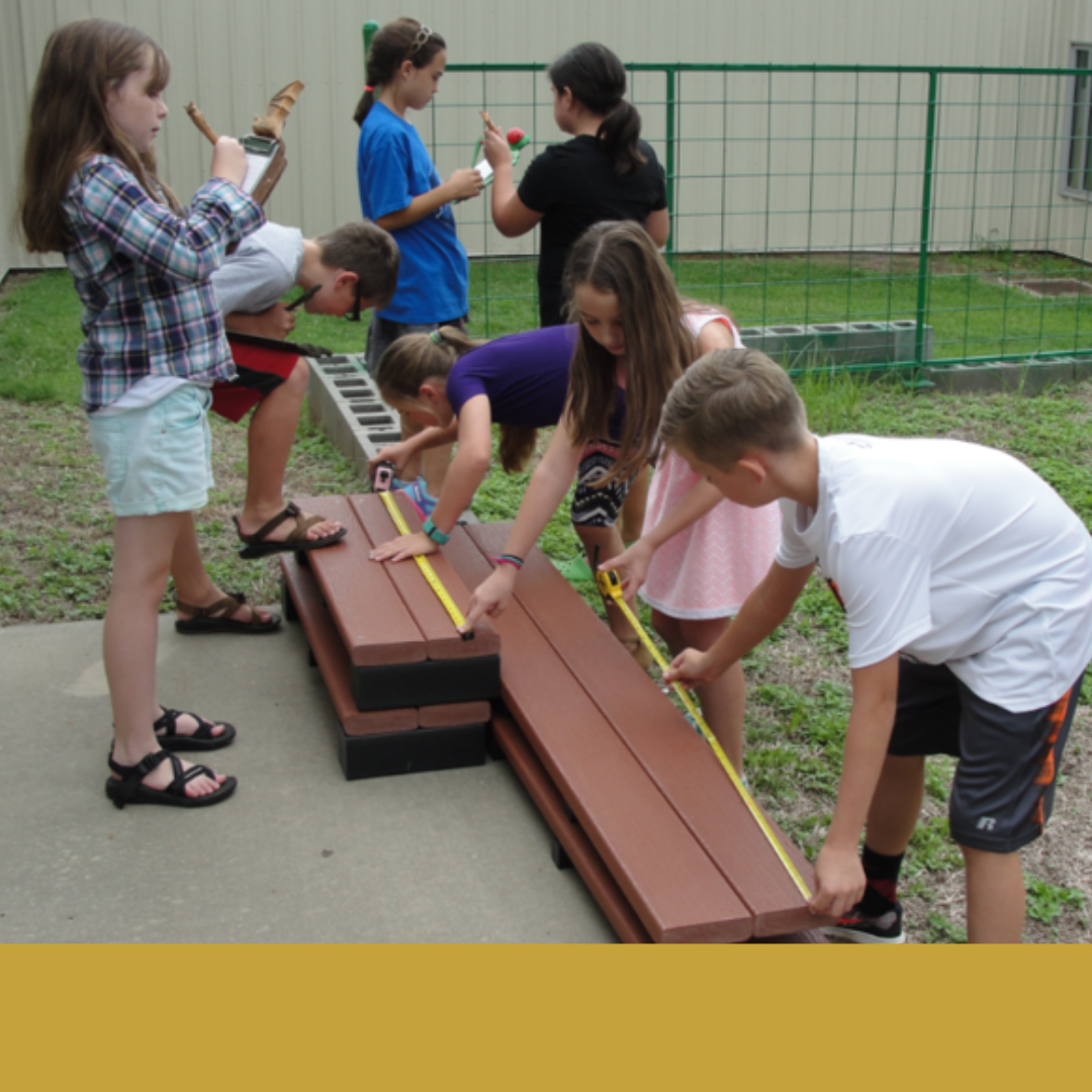 Children from the rural community alliance measure benches outside